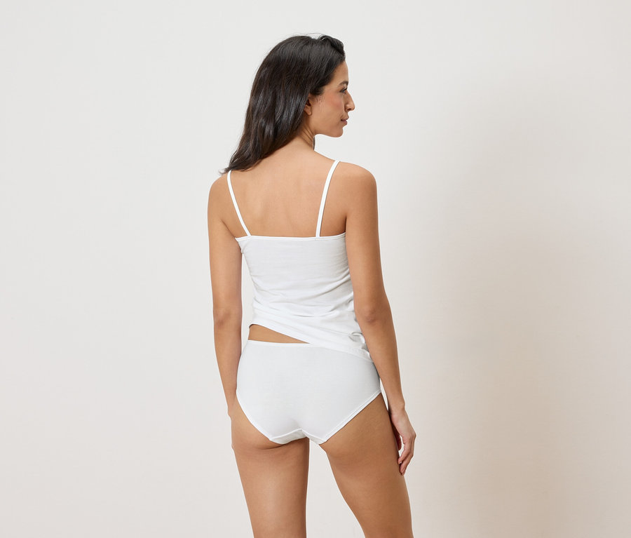 Vue arrière d'une femme aux cheveux foncés portant un débardeur blanc et une culotte assortie.