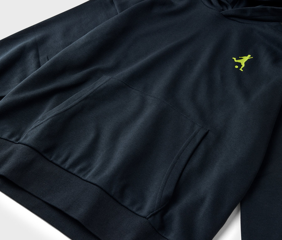 Gros plan d'un sweat à capuche bleu foncé avec une seule poche plaquée et un logo vert clair d'une personne jouant au football.