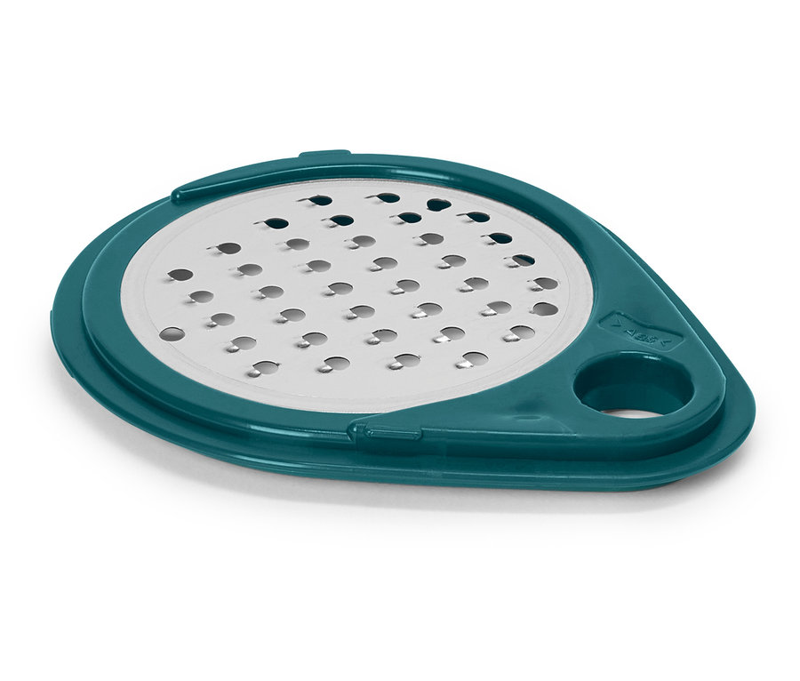 Une râpe à fromage ronde avec un bord turquoise repose sur une surface blanche.