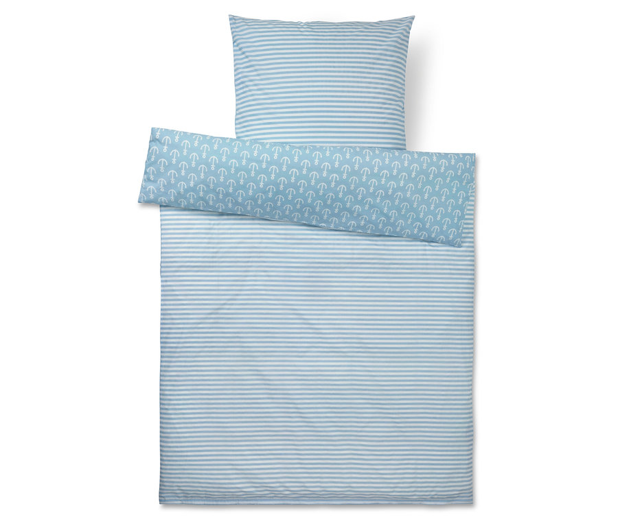 Vue de dessus d'un ensemble de literie à rayures bleu et blanc comprenant un oreiller, une couette et une housse à motif d'ancres.