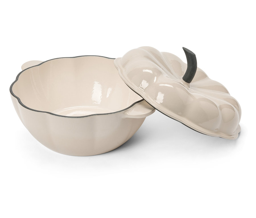 Une cocotte en forme de citrouille couleur crème avec un couvercle sur une surface blanche.