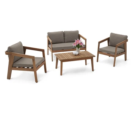 Photo d'un ensemble de meubles de jardin comprenant un canapé deux places, deux fauteuils et une table basse en bois avec des coussins gris et une composition florale.
