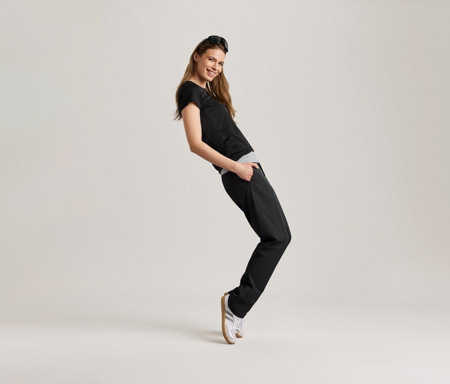 Femme posant en t-shirt de sport noir.