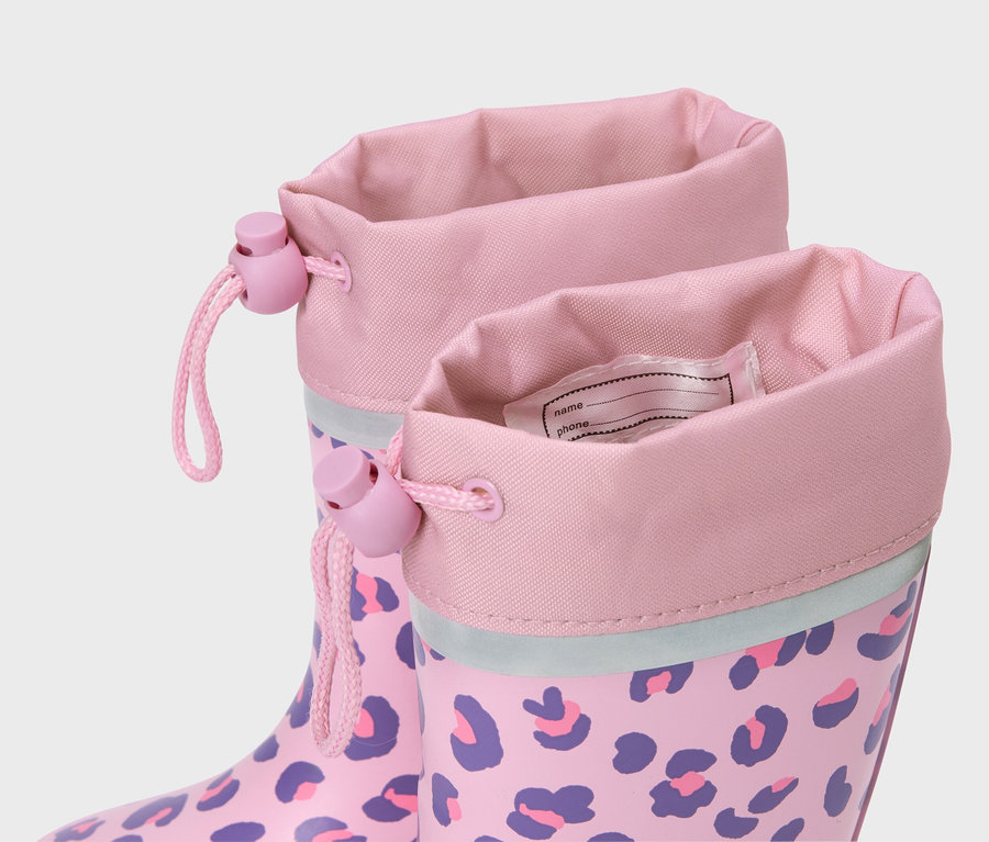 Gros plan de bottes de pluie roses à motif léopard violet avec étiquette de nom.