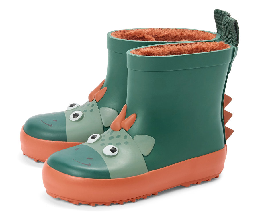 Des bottes en caoutchouc vertes avec une semelle orange et un motif de dinosaure se tiennent côte à côte.