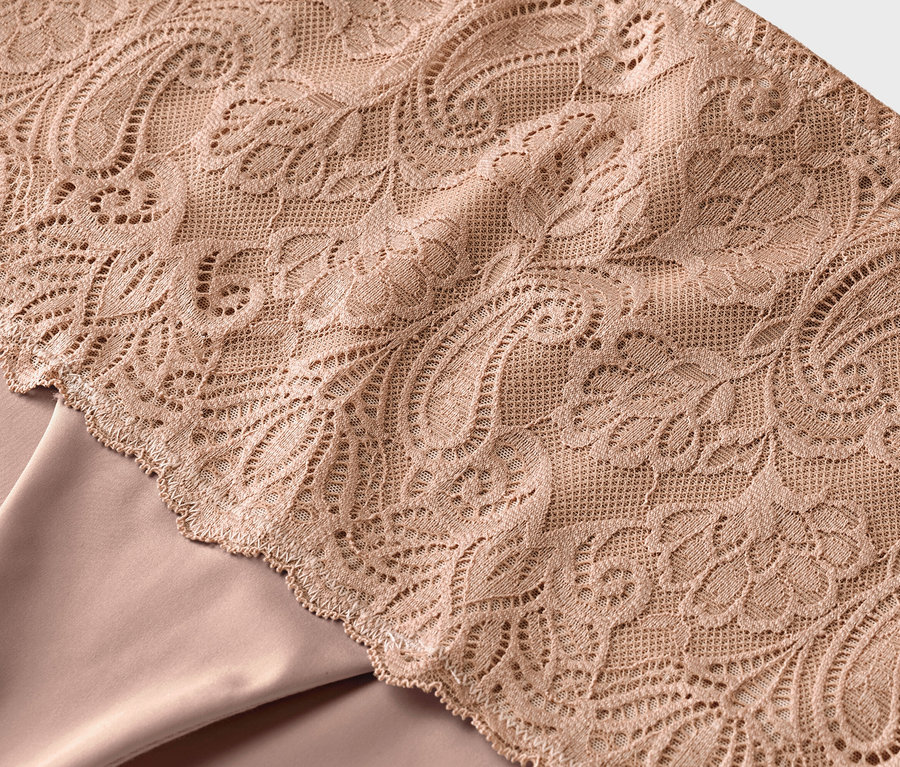 Gros plan d'un tissu beige orné de dentelle florale.