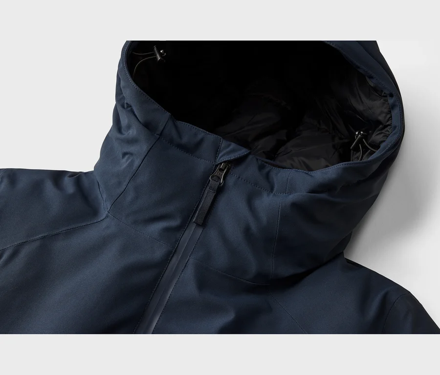 Veste bleu foncé avec capuche, fermeture éclair et doublure noire, gros plan sur la partie supérieure.