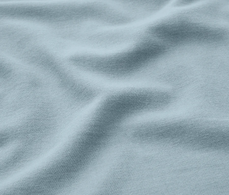 Tissu bleu clair avec des plis doux et des ombres.