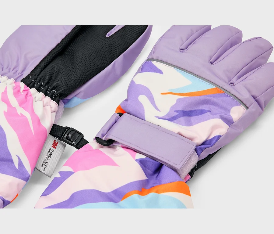 Une paire de gants d'hiver avec un motif abstrait et coloré en violet, rose, bleu, orange et blanc. Les gants ont des paumes violet clair, des poignets élastiques, des sangles de poignet réglables et une bande réfléchissante. Une étiquette « 3M Thinsulate Insulation » est visible.