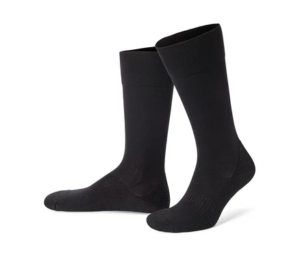 Deux chaussettes montantes noires côtelées se tiennent sur un fond blanc.