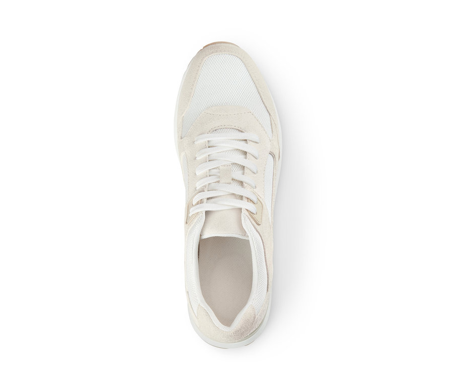 Gros plan d'une basket en cuir velours sur un fond blanc.