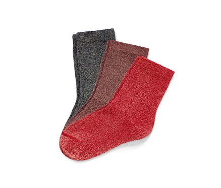 Trois paires de chaussettes scintillantes pour enfant superposées.