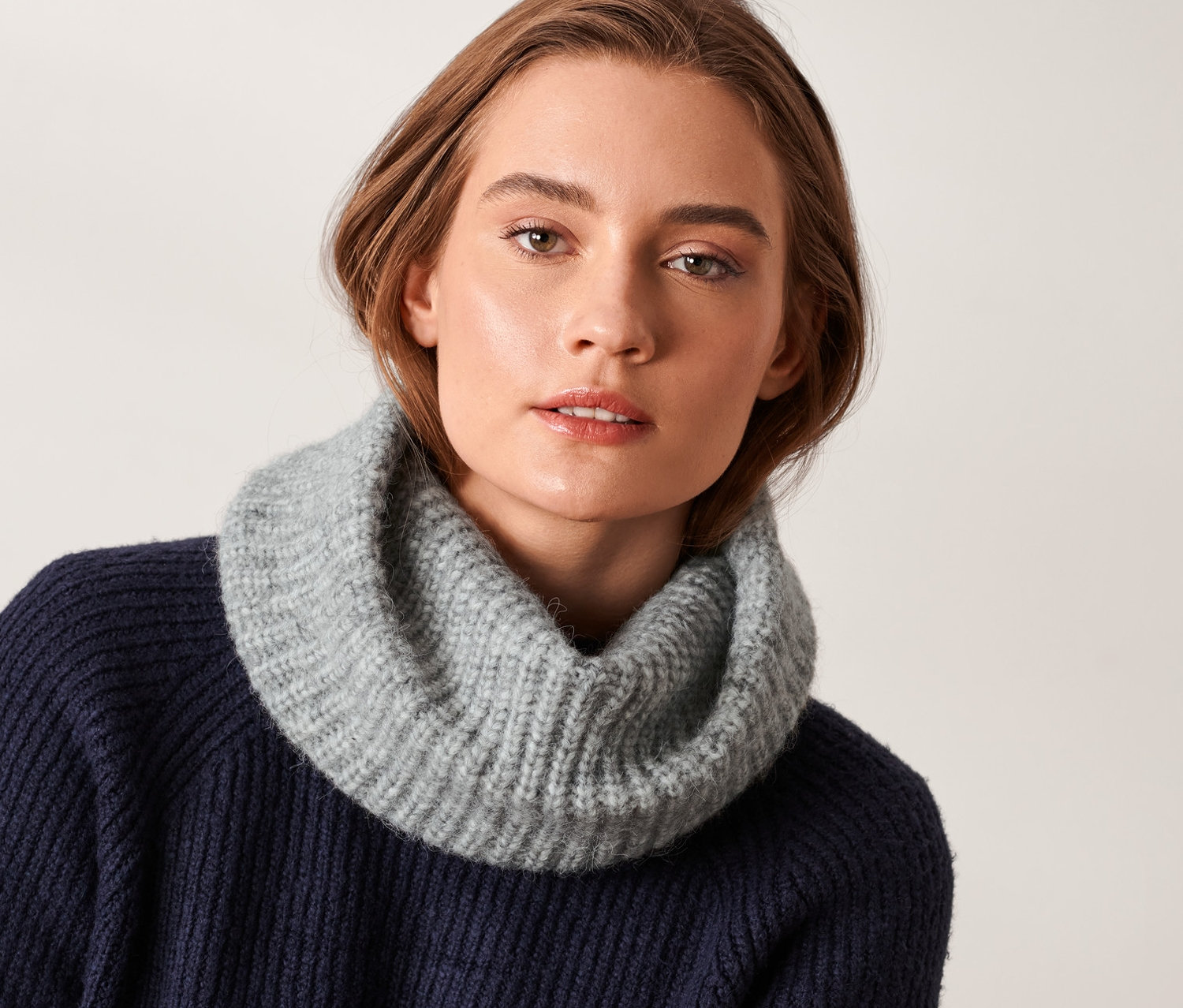 Femme portant une écharpe tube tricotée.