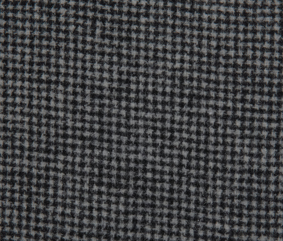 Gros plan sur le tissu à carreaux d'un manteau court.