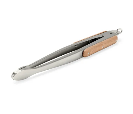 Une pince à barbecue en acier inoxydable avec une poignée en bois placée en diagonale sur un fond blanc.