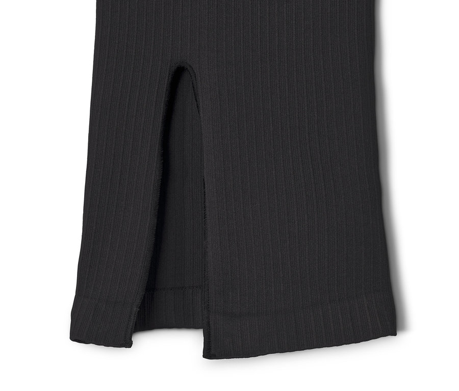 Gros plan sur un pantalon de sport évasé sans coutures noir, avec fente.