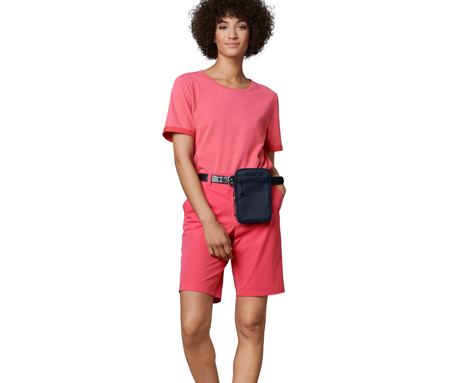 Femme posant avec un sac bandoulière.