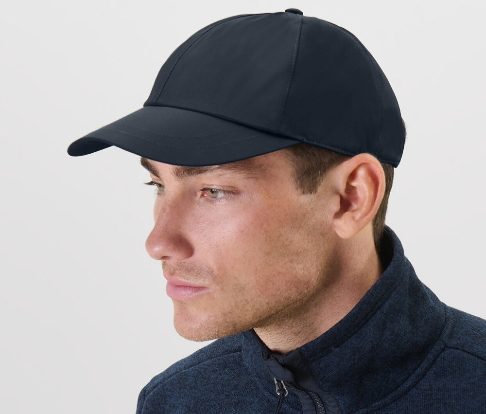Un homme portant une casquette polyvalente bleue et une veste bleue.