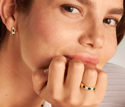 Femme portant une bague Noir et Blanc, une chaîne et des créoles Noir et Blanc.