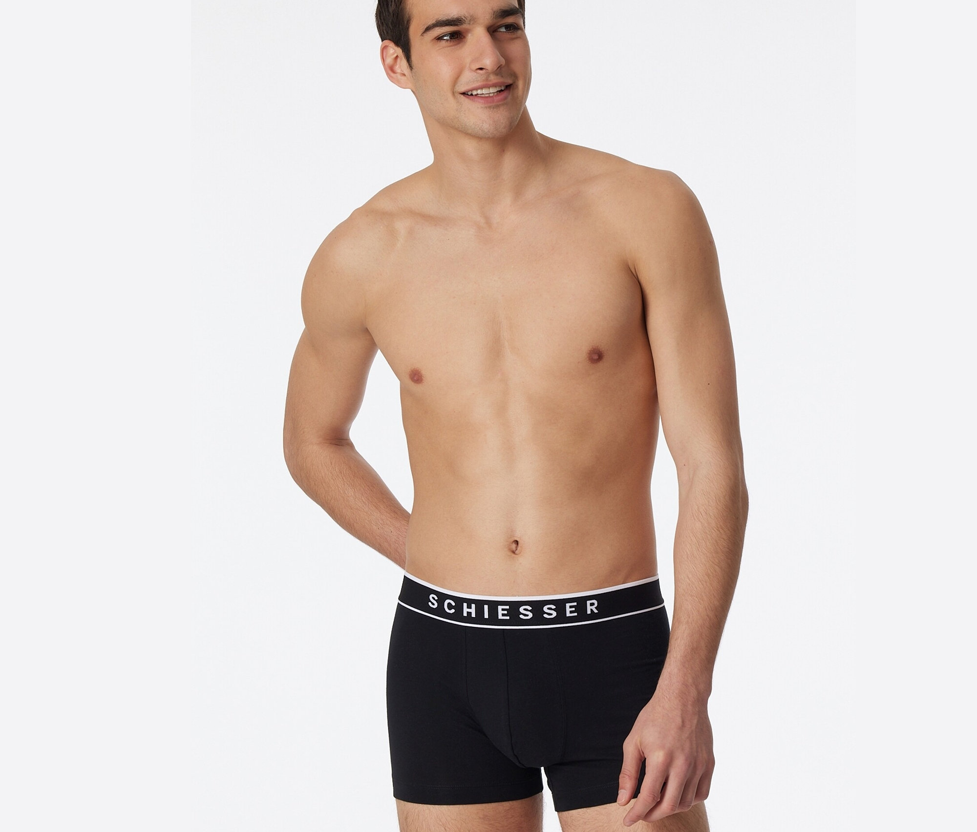 Homme torse nu posant en 3 boxers SCHIESSER avec coton bio, noir.