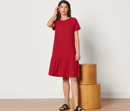 Femme posant dans une robe en jersey à volants rouge.
