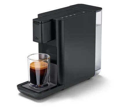 Une machine à café Qbo ICONIC Dark Chrome avec une tasse de café.