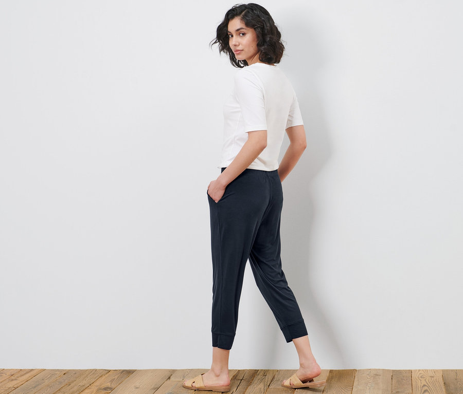 Femme regardant par-dessus son épaule et posant en pantalon 3/4 en jersey et t-shirt.