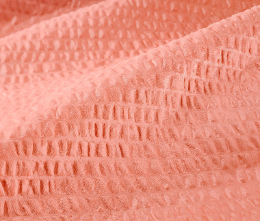 Gros plan d'une parure de lit en seersucker de taille standard dans une couleur rose saumon.