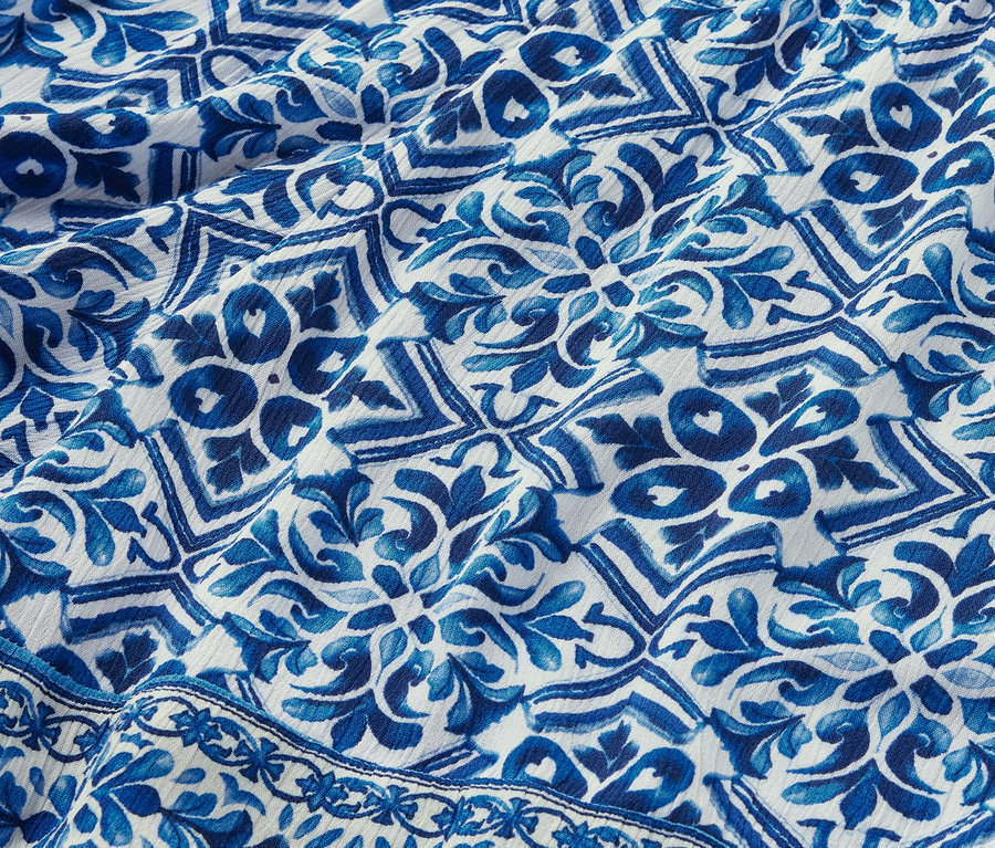 Gros plan sur un short tissé imprimé avec un motif bleu et blanc.