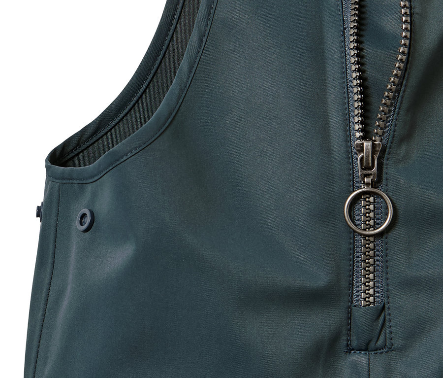 Détail d'un pantalon imperméable pour tout-petit avec fermeture éclair et bouton.