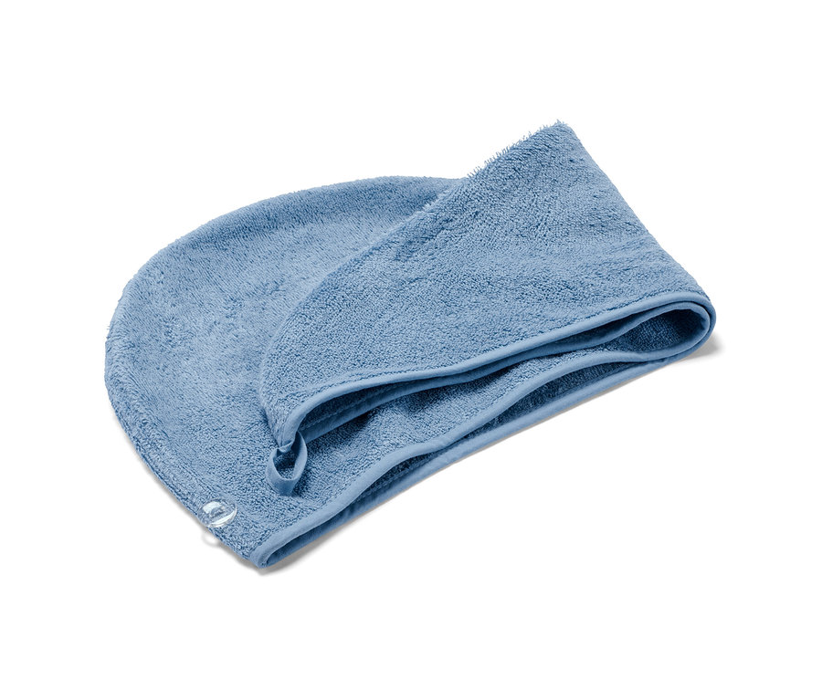 Une serviette turban bleue sur fond blanc.