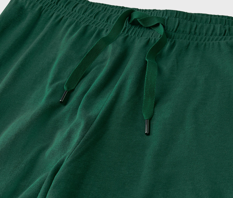 Gros plan sur un pantalon de survêtement vert avec cordon de serrage.