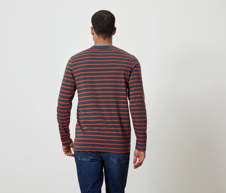 Un homme vu de dos porte un t-shirt rayé à manches longues et un jean.