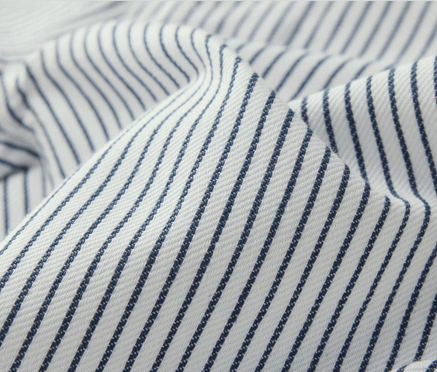 Gros plan d'un pantalon tissé pour enfant rayé bleu sur fond blanc.