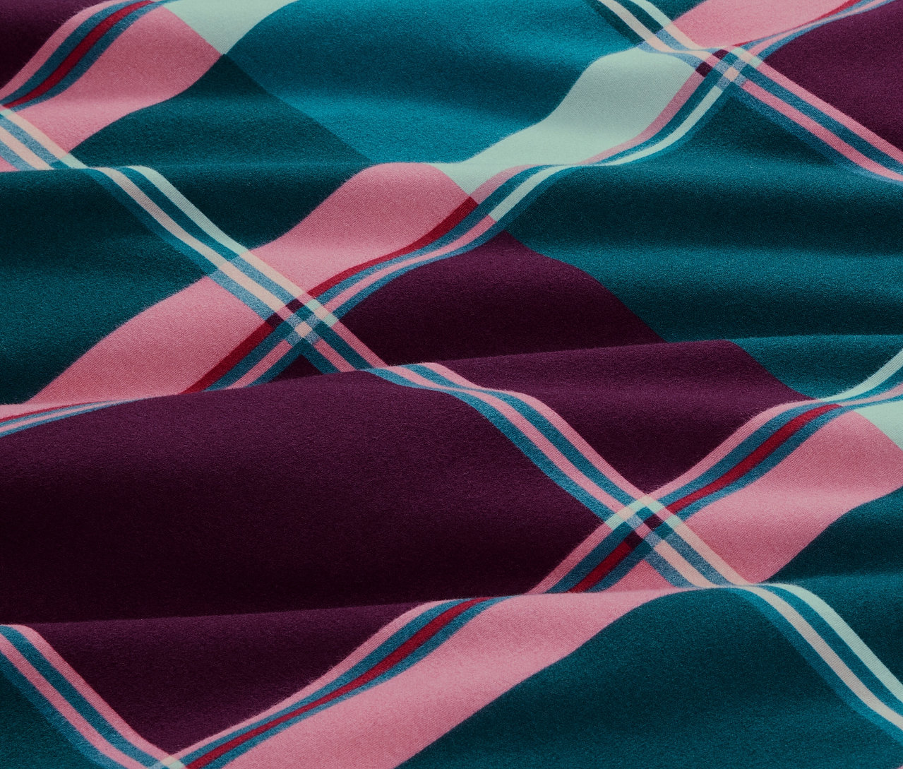 Gros plan sur une parure de lit en molleton de taille standard à carreaux dans les tons bleu, rose et violet.