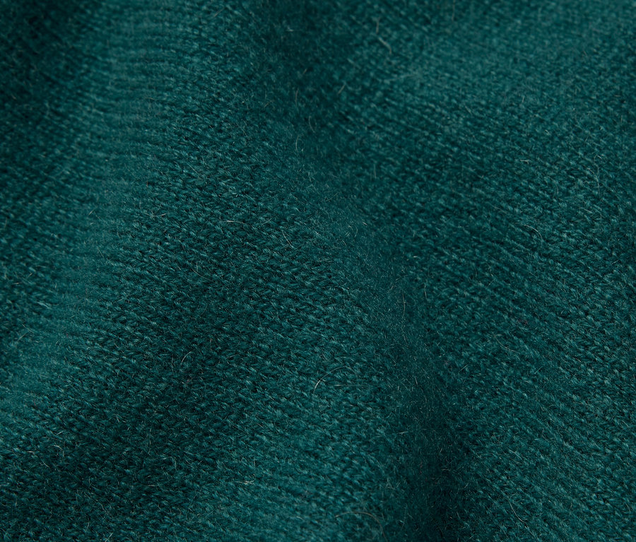 Gros plan d'un tissu texturé vert émeraude.