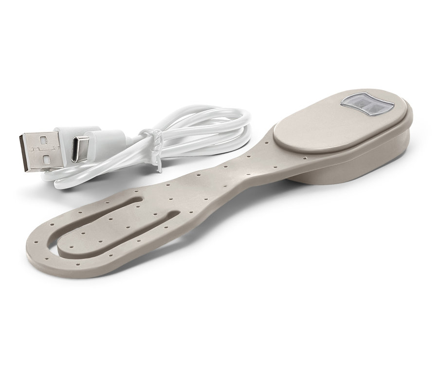 Un clip de livre beige avec une lumière et un câble de chargement USB inclus est posé sur un fond blanc.