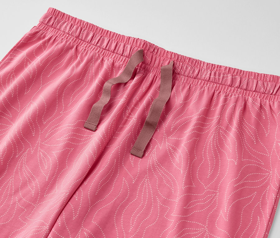 Détail d'un pyjama rose à motif de feuilles.