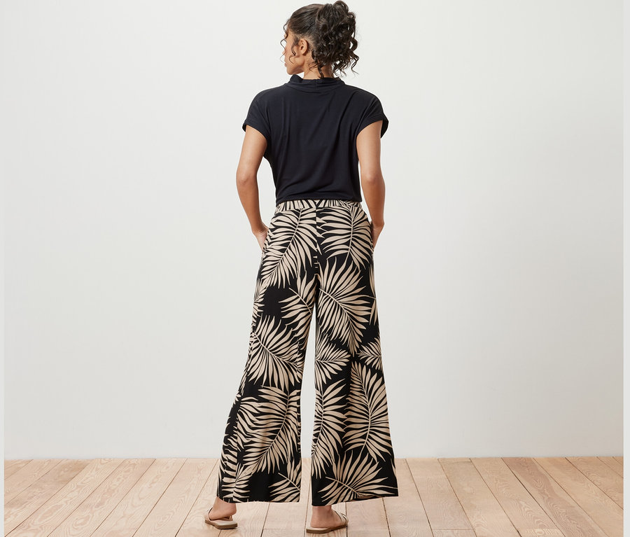 Femme posant en pantalon palazzo imprimé.