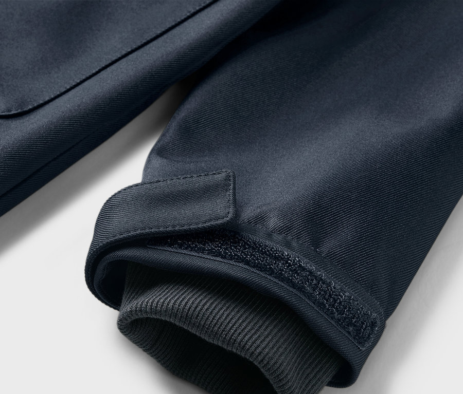Gros plan sur la manche d'un manteau en softshell pour enfant avec un revers.