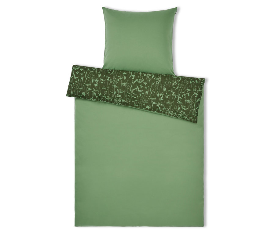 Linge de lit vert avec motif floral et oreiller sur le dessus.