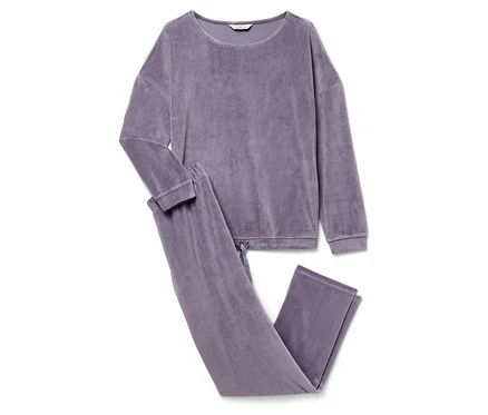 Un pyjama en velours violet avec des manches longues et un pantalon est posé sur un fond blanc.