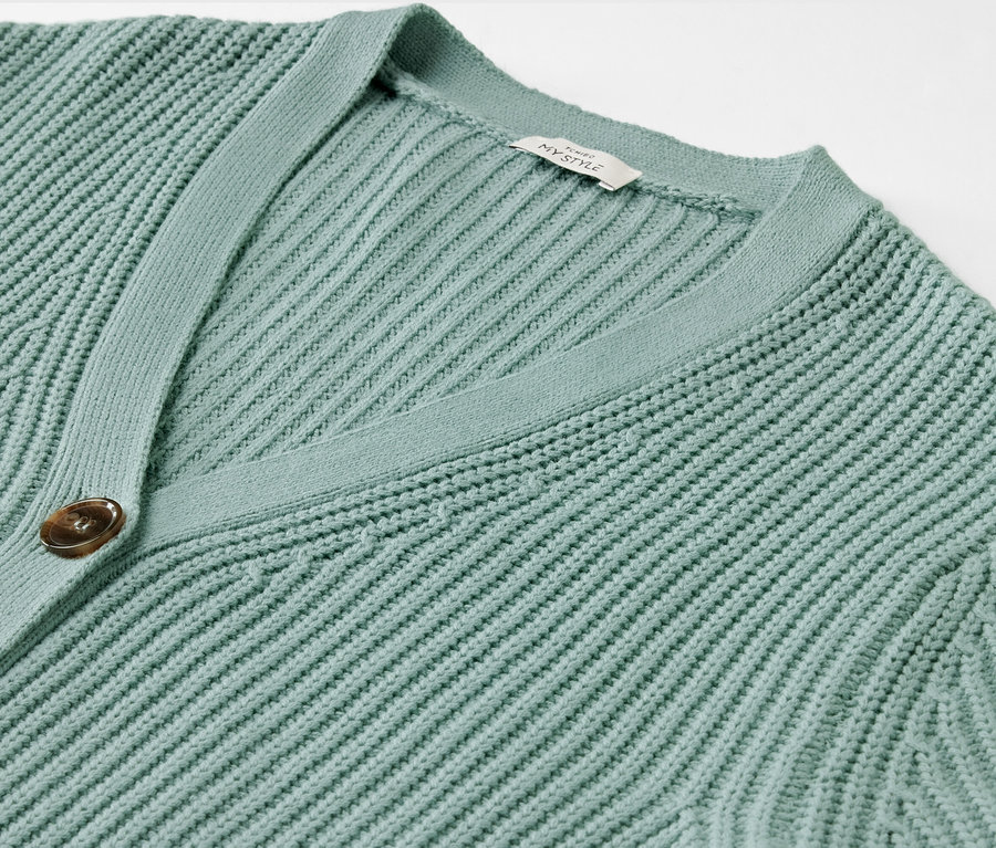 Détail d'un cardigan en grosse maille sauge.
