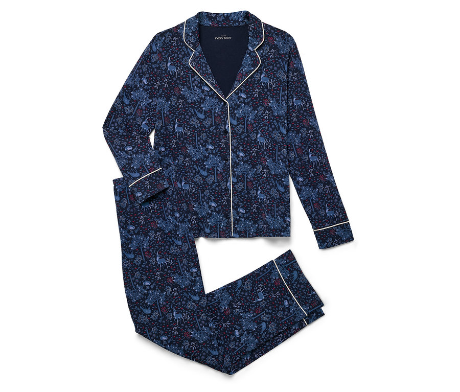 Un ensemble de pyjama bleu marine avec imprimé intégral est plié sur un fond blanc.