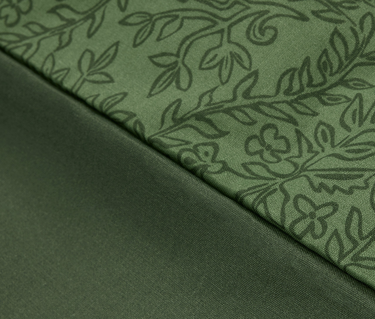 Gros plan d'un tissu vert à motif floral et d'un tissu vert lisse.