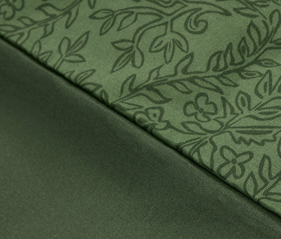Gros plan d'un tissu vert à motif floral et d'un tissu vert lisse.