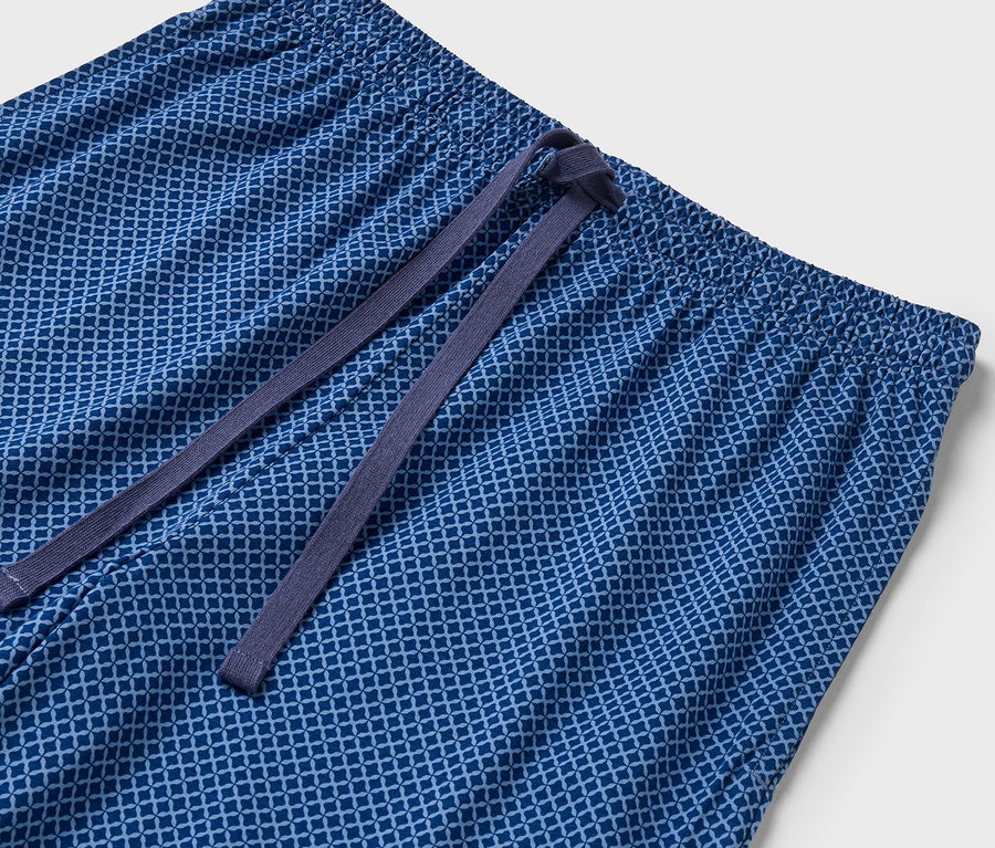 Gros plan d'un pantalon bleu à motifs avec une taille élastique et un cordon de serrage.