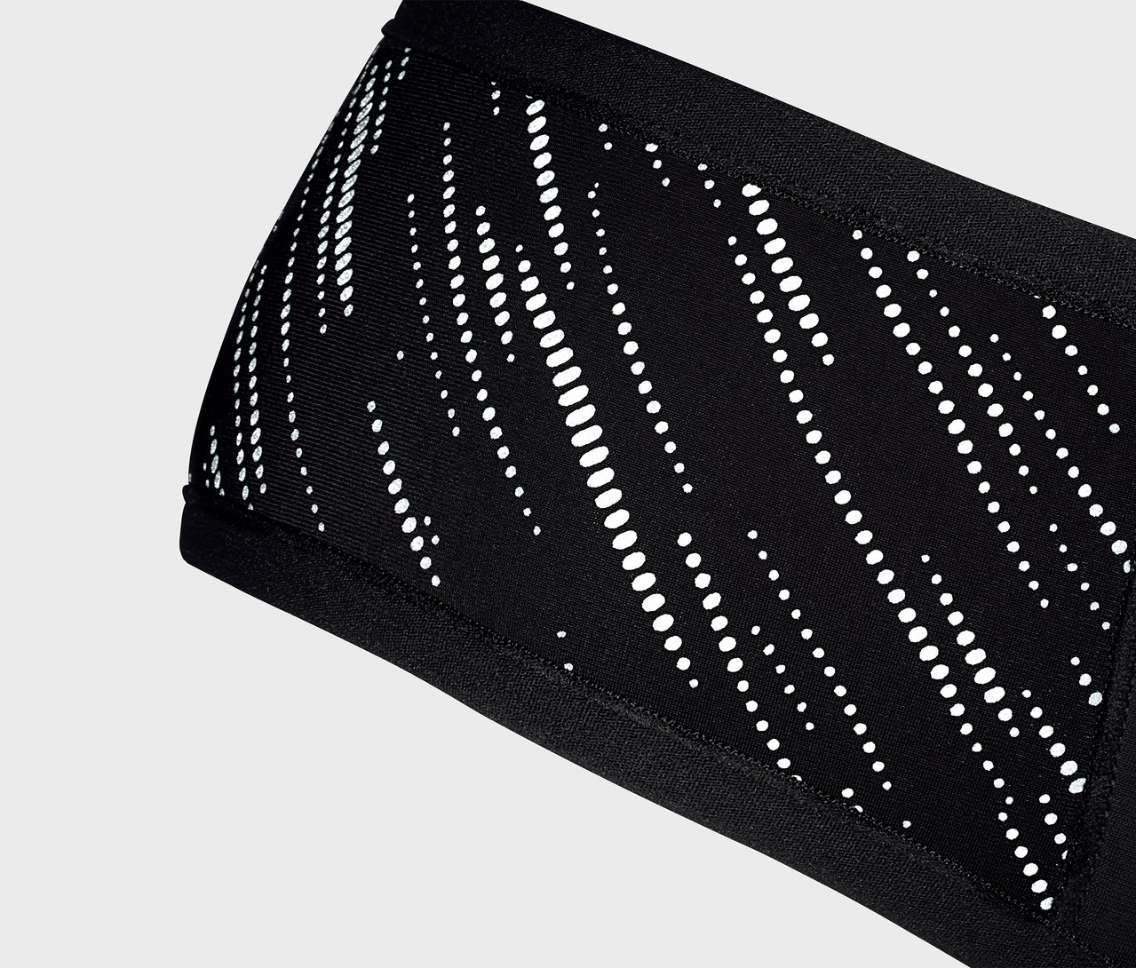 Gros plan d'un bandeau noir Windprotection-Stirnband avec un motif blanc.
