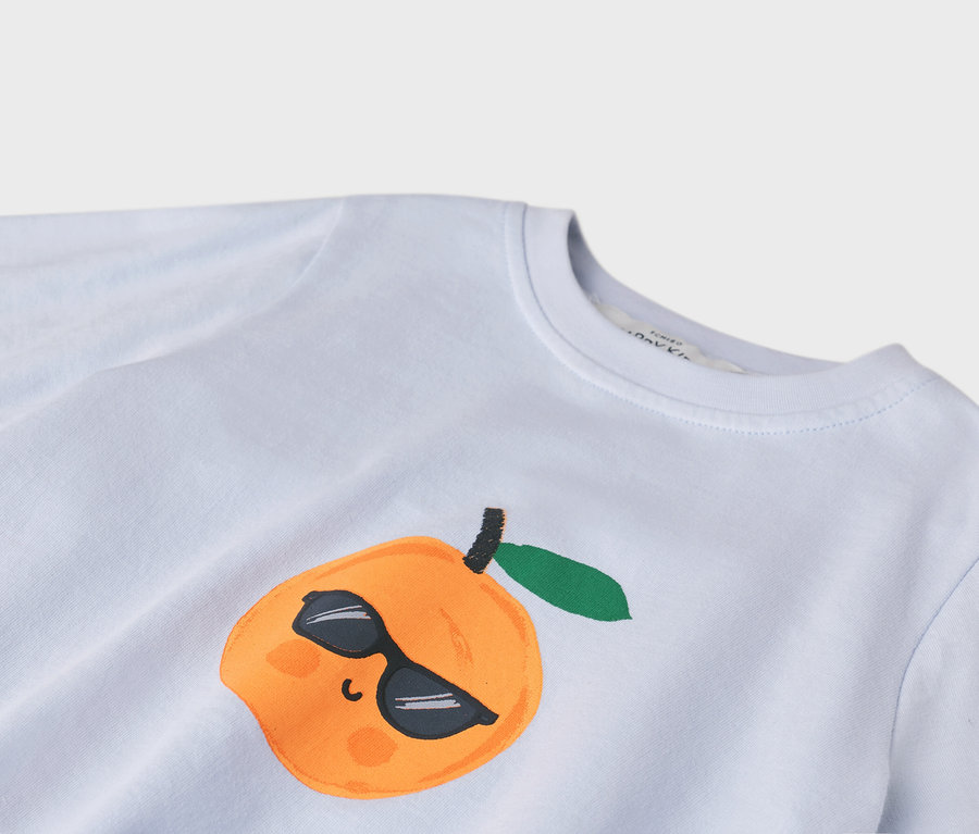 Gros plan d'un t-shirt bleu clair avec une illustration de pêche orange portant des lunettes de soleil.