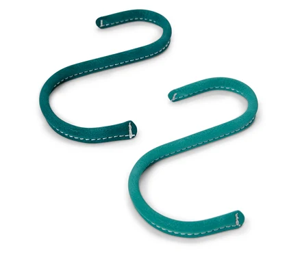 Deux crochets en S verts sont posés sur un fond blanc.